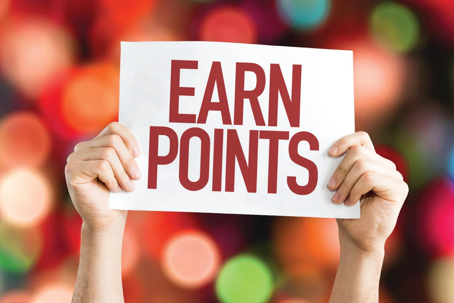 hands holding up a sign reading "earn points" over blurred background