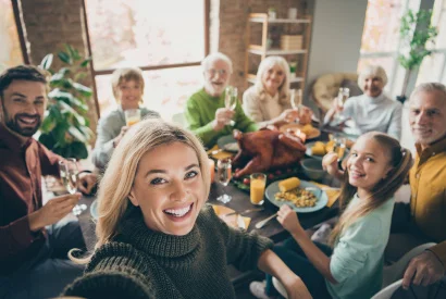 large family gathered around dinner table for thanksgiving dinner